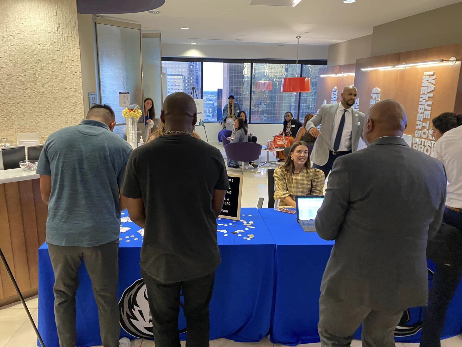 A group of people are standing around a table in a room.