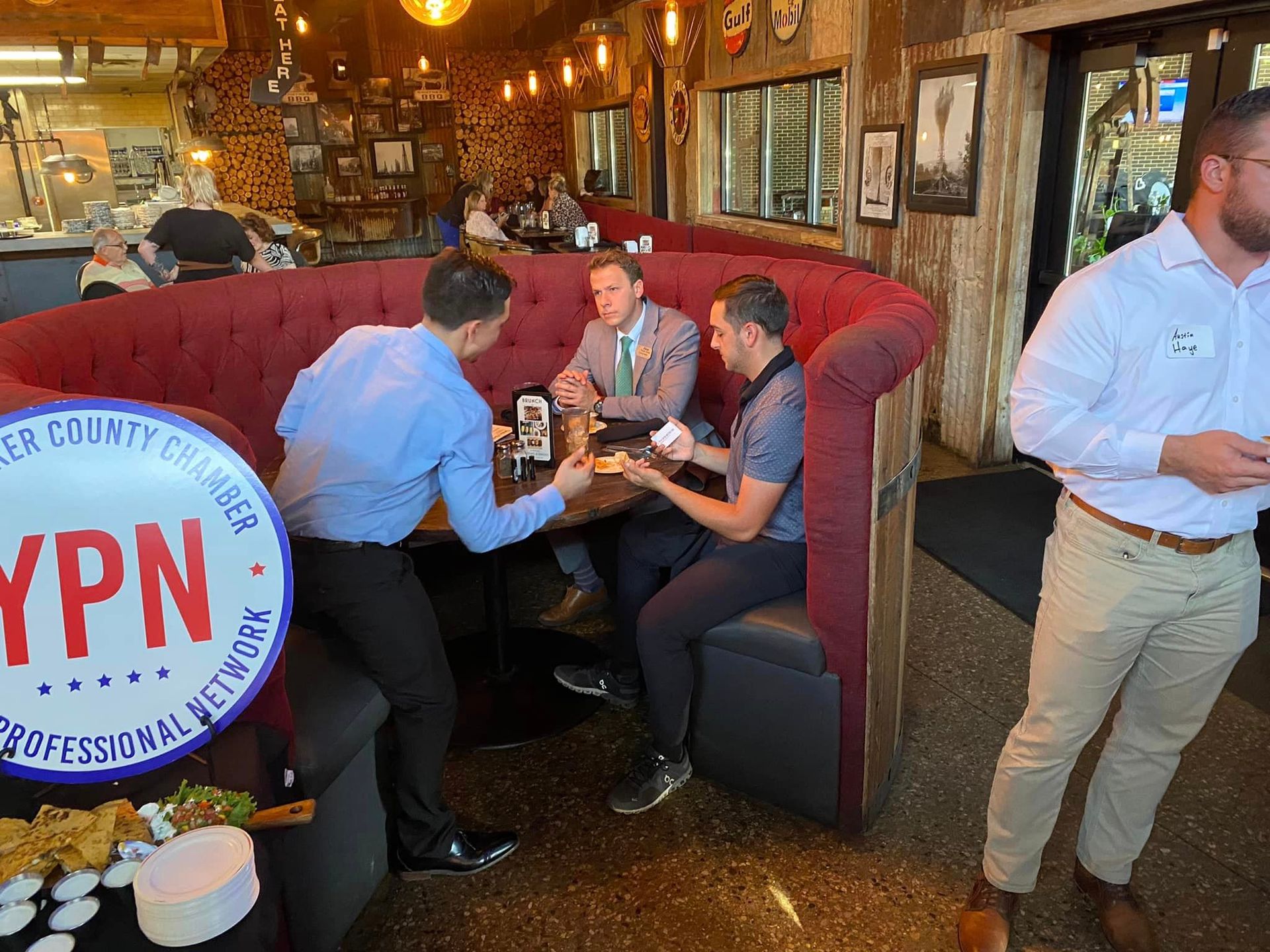 A group of men are sitting at a table in a restaurant.