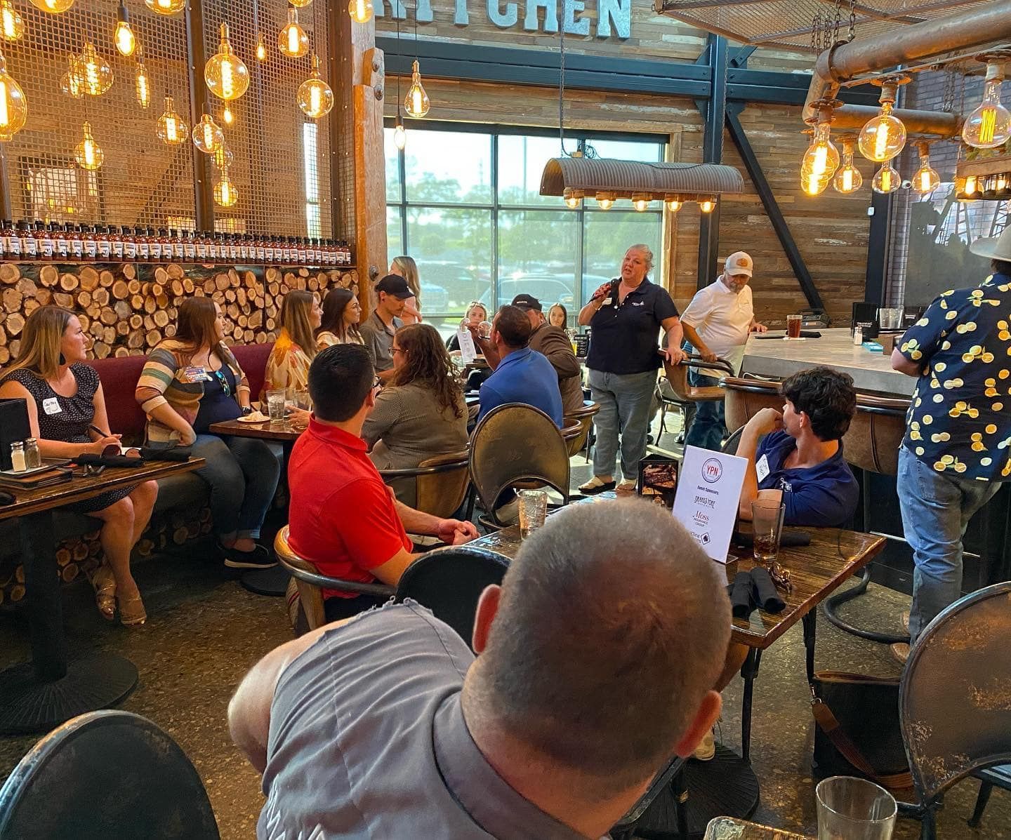 A group of people are sitting at tables in a restaurant.