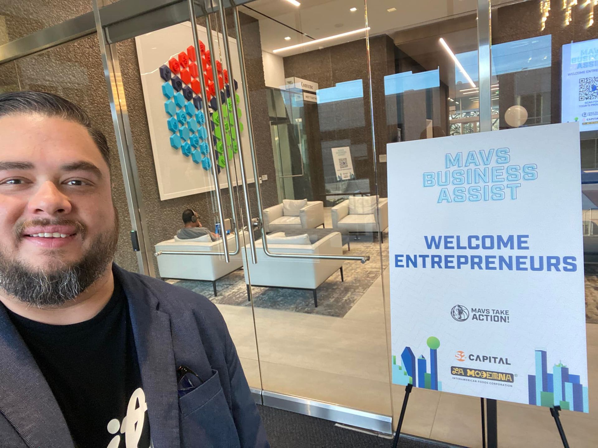 A man is standing in front of a welcome sign for entrepreneurs.