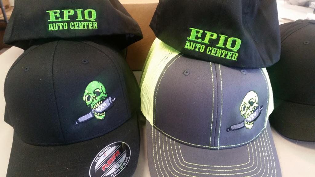 A stack of epic auto center hats on a table