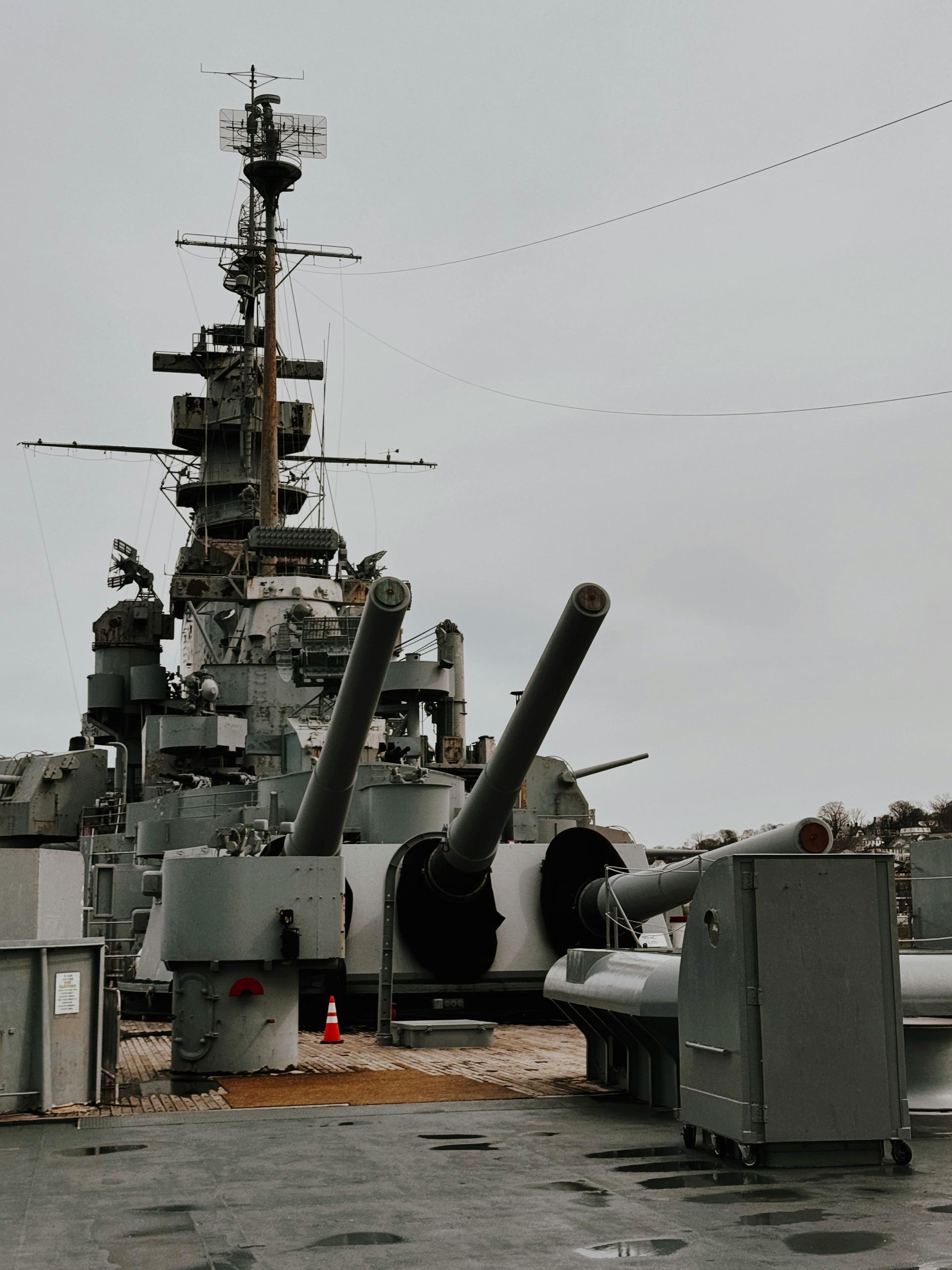 WE CAN HELP YOU JUST SEND US MESSAGE! Battleship stern with large guns, mast, and overcast sky.