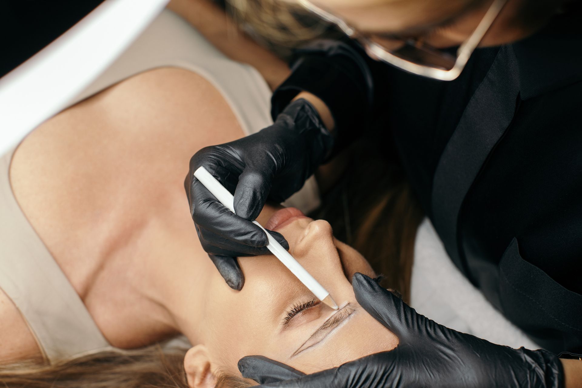 Una donna si sta facendo tatuare le sopracciglia da un tatuatore.