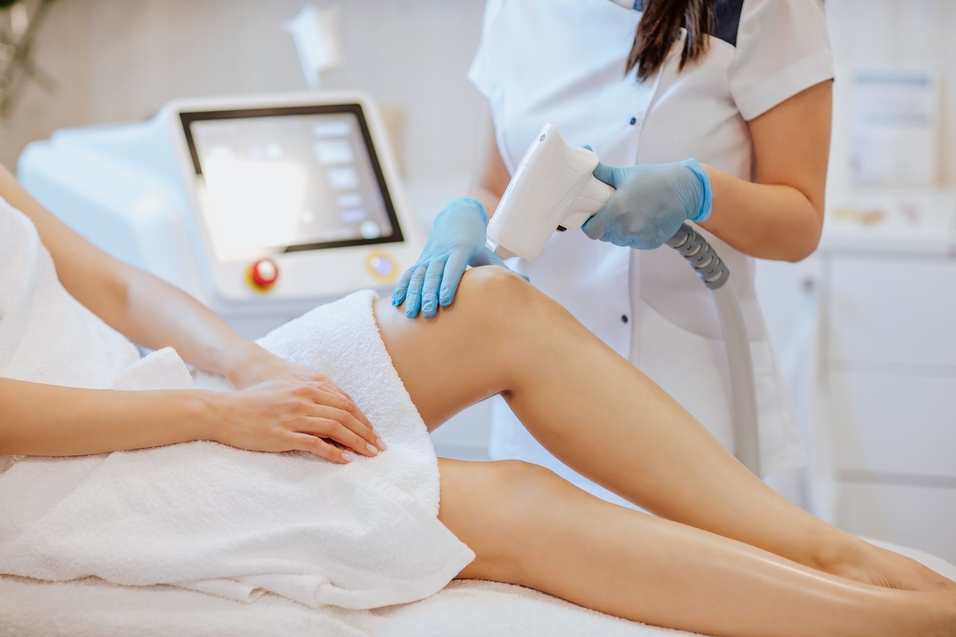 Una donna si sta sottoponendo a un trattamento di epilazione laser sulle gambe.