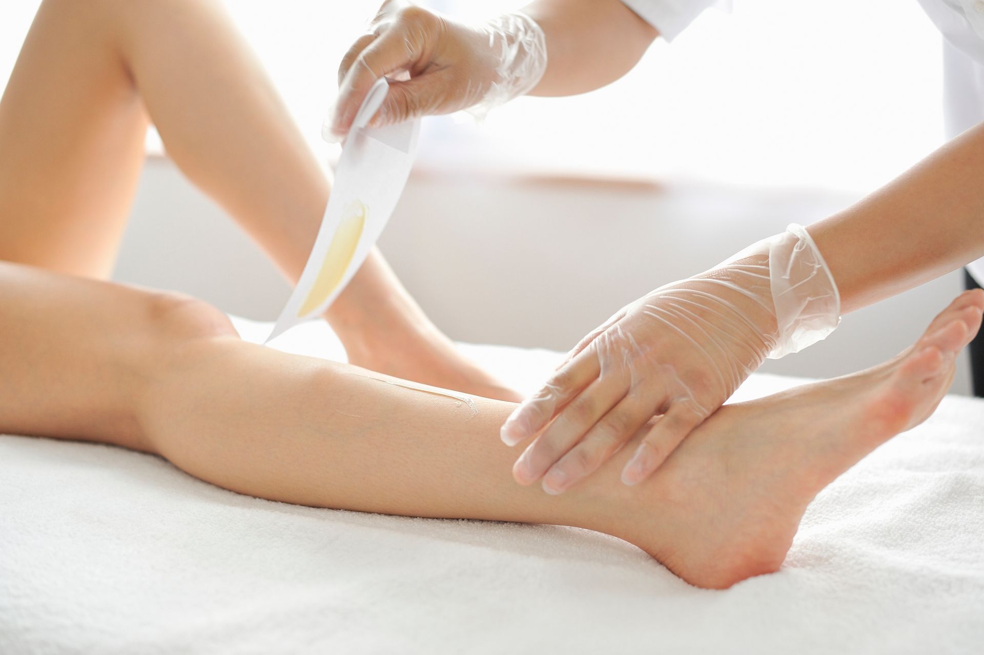 Una donna si sta facendo depilare le gambe in un salone di bellezza.