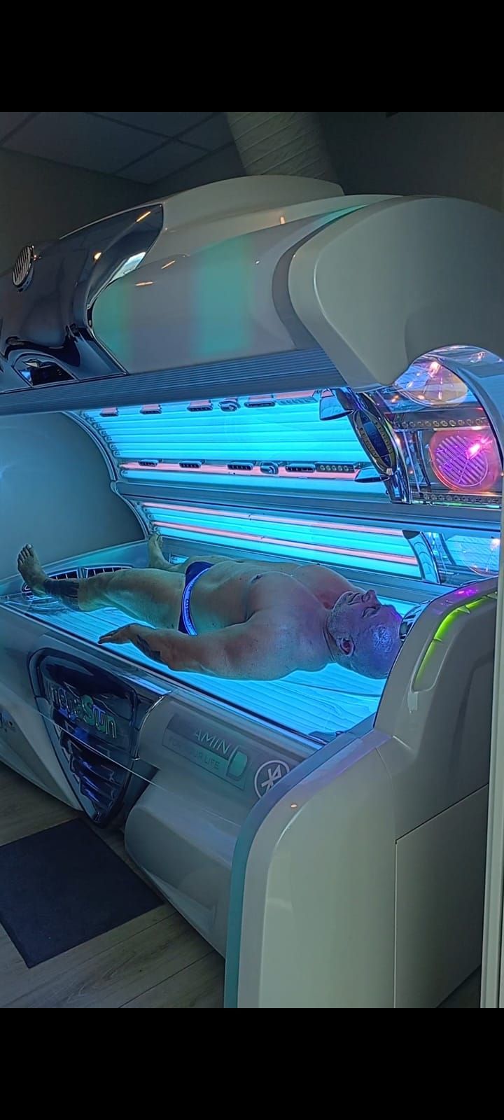 Una donna è sdraiata su un lettino abbronzante.