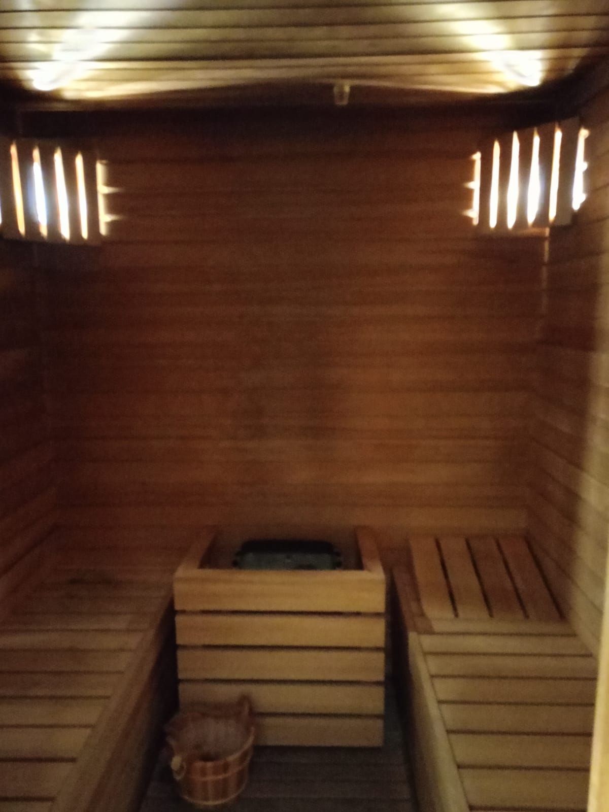 Una sauna in legno con un secchio sul pavimento