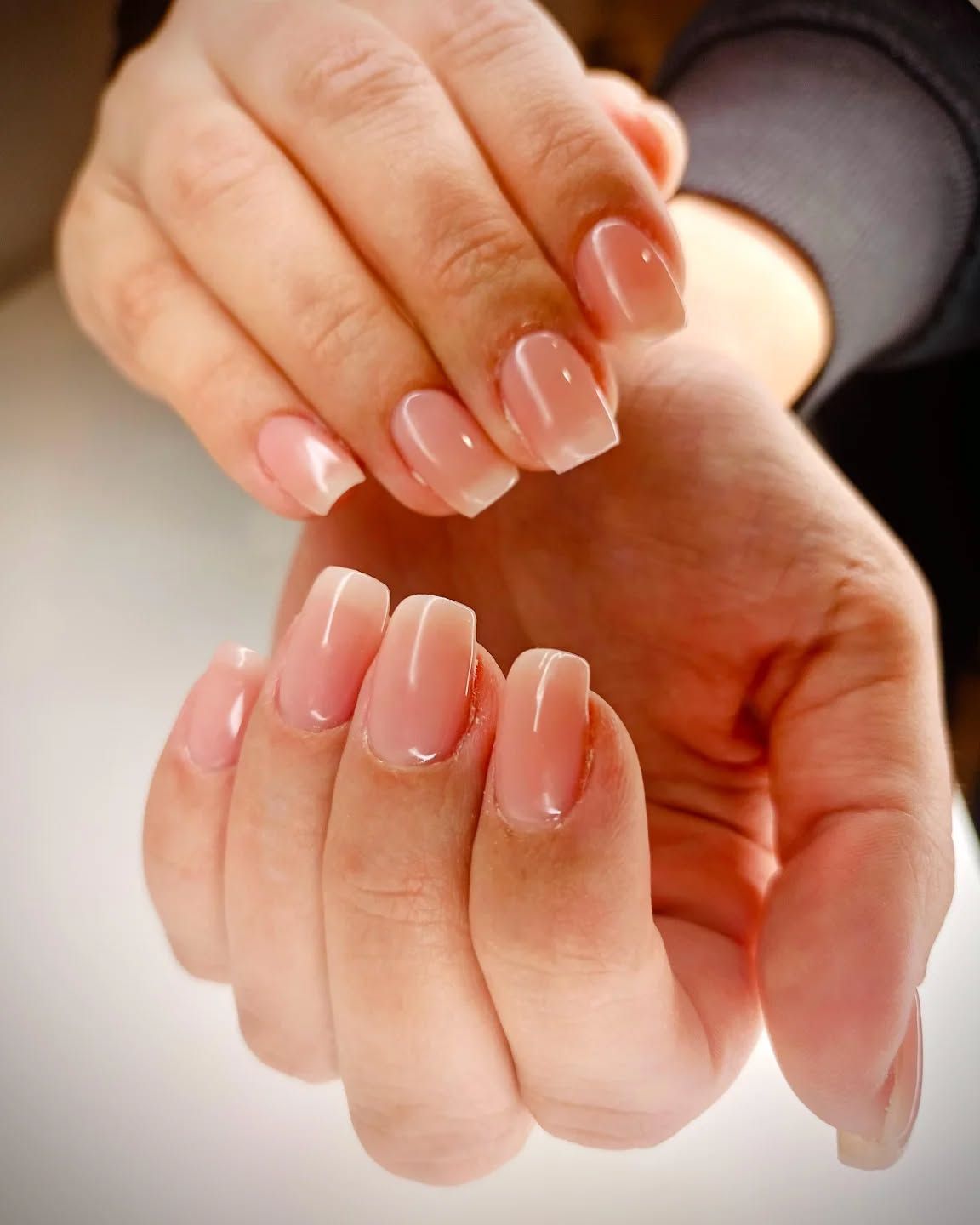 Un primo piano delle mani di una donna con le unghie rosa