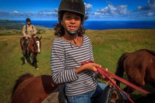 A young girl is riding a horse in a field.