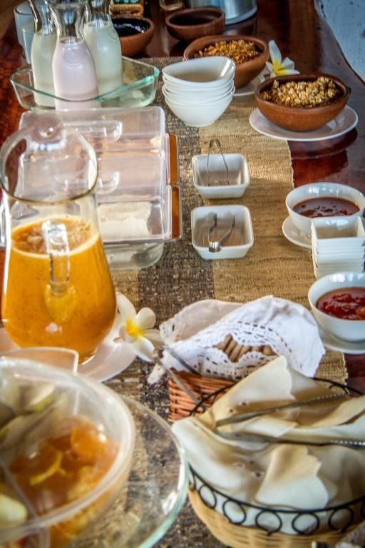 A table topped with bowls of food and a pitcher of orange juice.