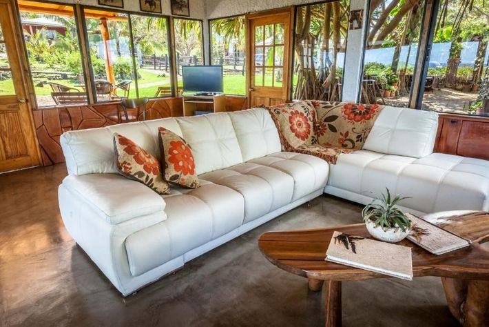 A living room with a large white couch and a wooden table.