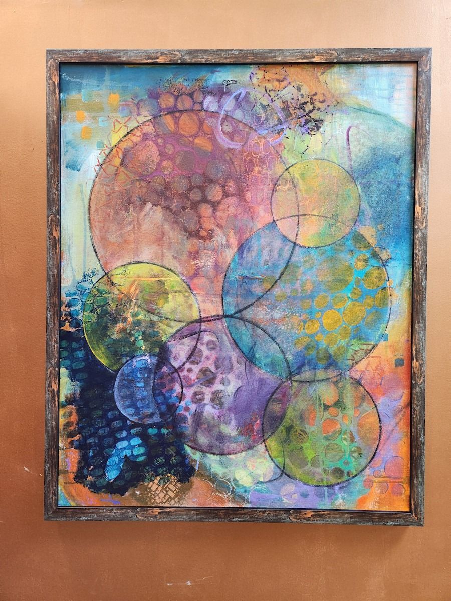 Abstract painting with overlapping colorful circles, framed.