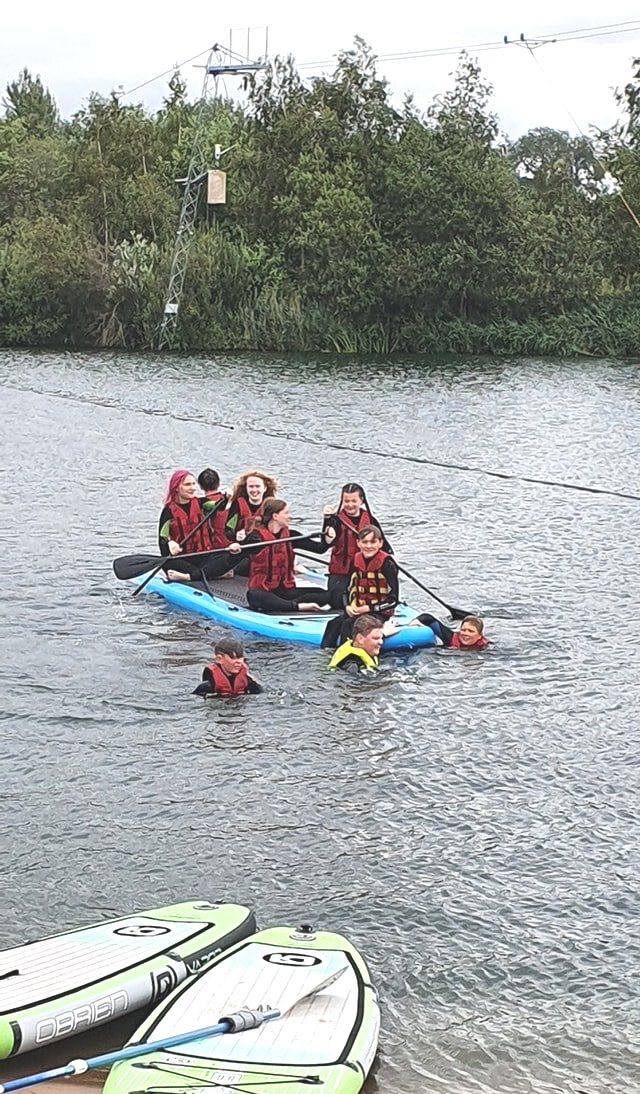 A group of people are paddling kayaks on a lake.
