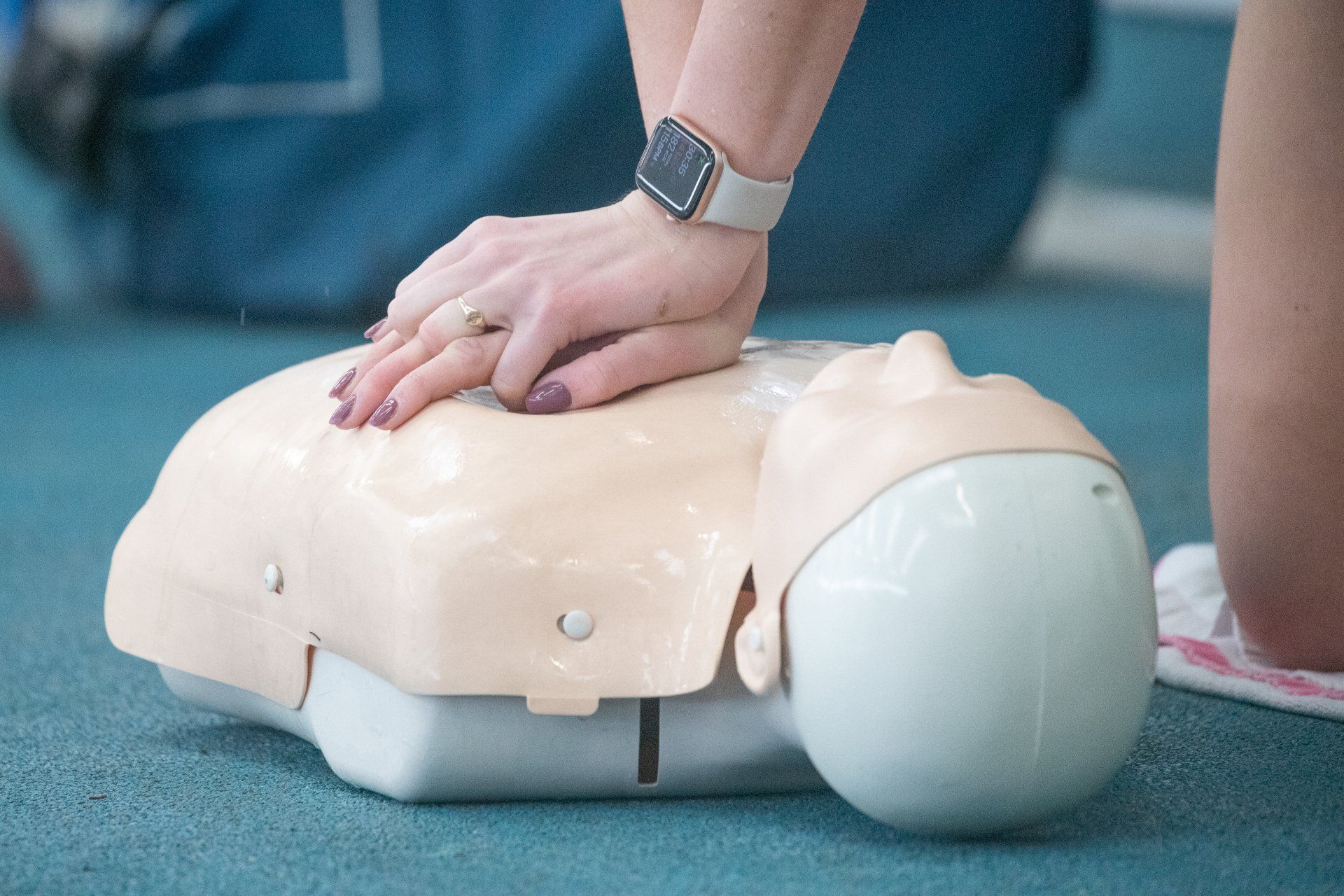 A woman is doing a cpr on a mannequin.