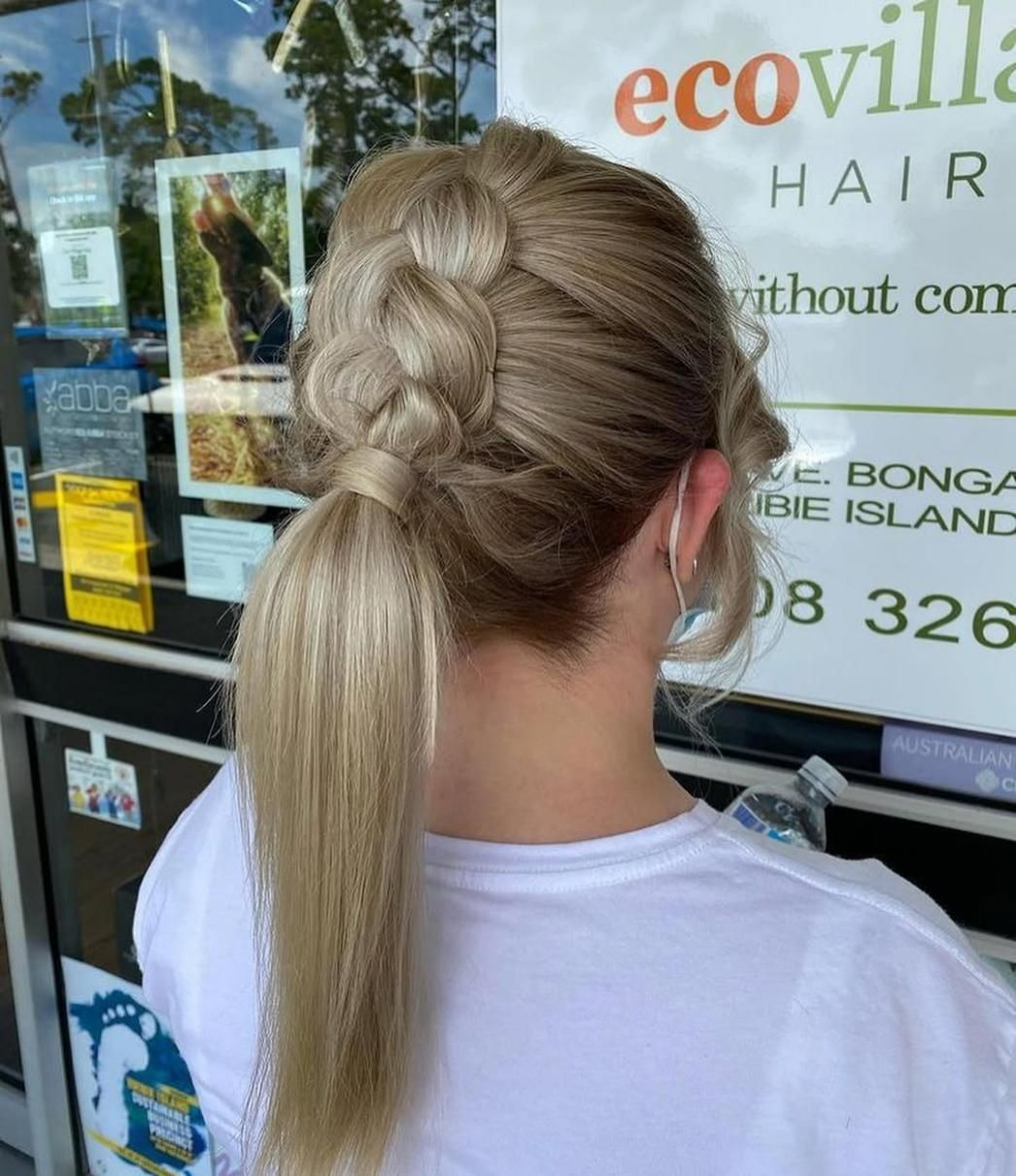 A Woman with Blonde Hair Is Wearing a Braided Ponytail — Eco Village Hair in Bongaree, QLD