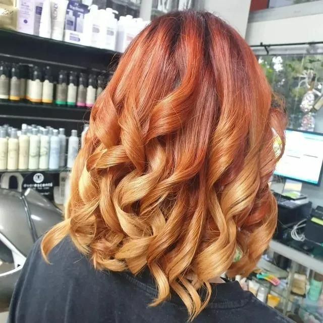 A Woman with Red Hair Is Wearing a Black Shirt — Eco Village Hair in Bongaree, QLD