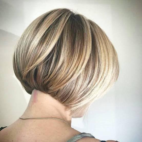 A Woman With Short Blonde Hair is Wearing a Necklace — Eco Village Hair in Bongaree, QLD