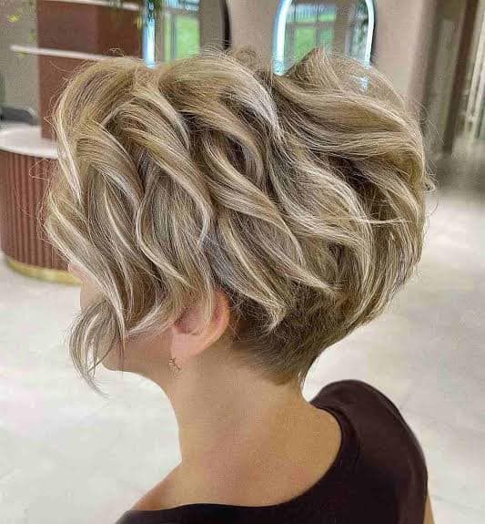 A Woman With Short Blonde Hair is Wearing a Black Shirt — Eco Village Hair in Bongaree, QLD