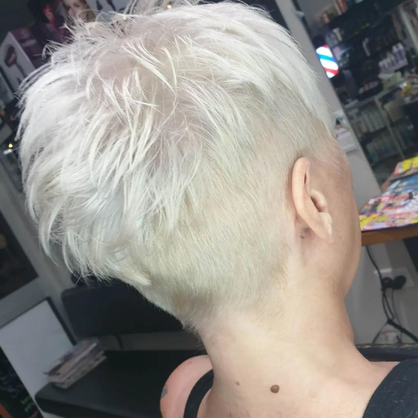 A Woman with Short White Hair Is Sitting in A Salon — Eco Village Hair in Bongaree, QLD