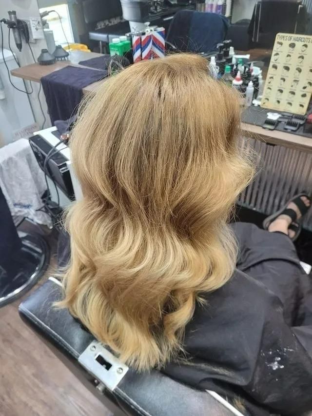 A Woman with Blonde Curly Hair Is Sitting in A Chair in A Salon — Eco Village Hair in Bongaree, QLD