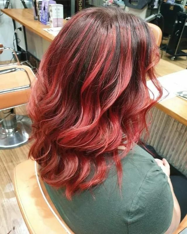 A Woman with Red Hair Is Sitting in A Chair in A Salon — Eco Village Hair in Bongaree, QLD