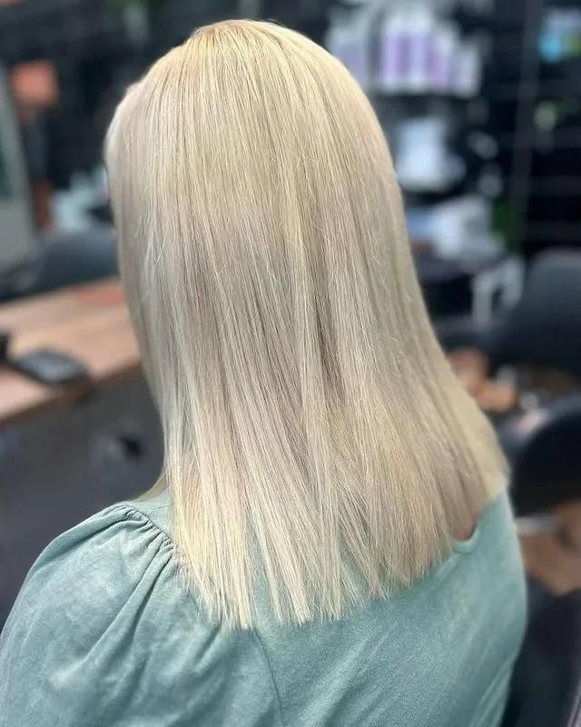 A Woman with Blonde Hair Is Sitting in A Chair in A Salon — Eco Village Hair in Bongaree, QLD