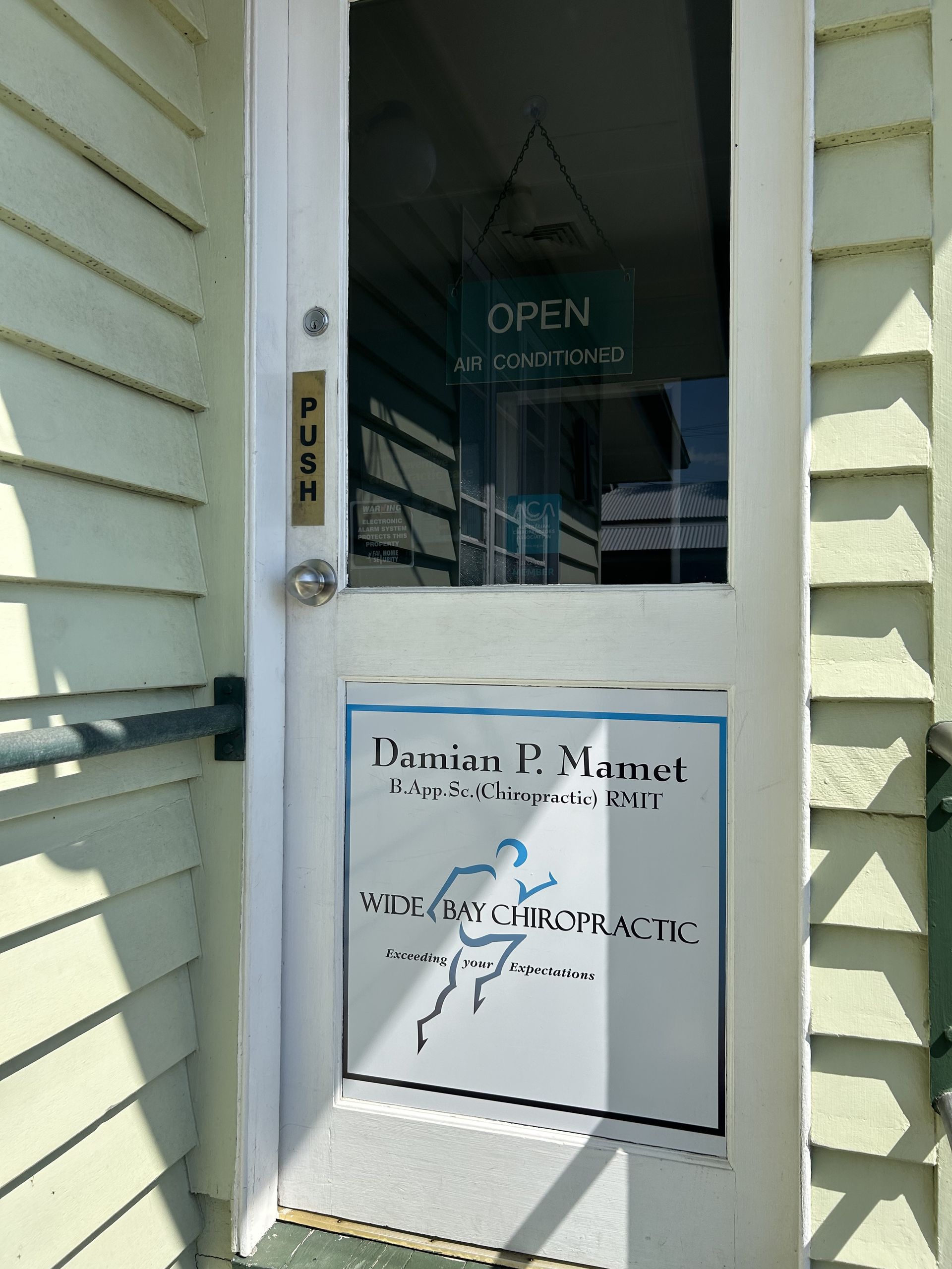 White Door With a Sign for Damien P. Manet, Saco Chiropractic — Wide Bay Chiropractic in Gympie, QLD