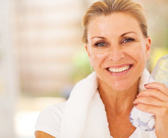 Woman With Towel and Water Bottle — Wide Bay Chiropractic in Gympie, QLD