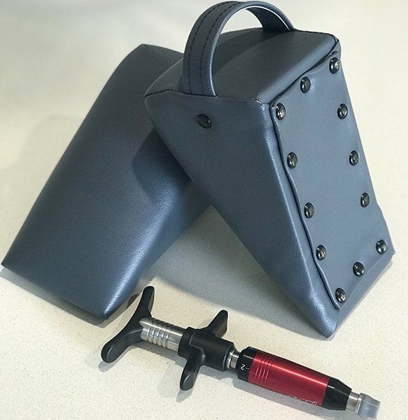 Two Blue Chiropractic Wedges With a Tool — Wide Bay Chiropractic in Gympie, QLD