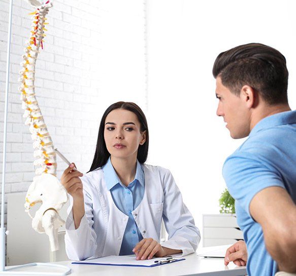 Woman Doctor Pointing at Spine Model — Wide Bay Chiropractic in Gympie, QLD