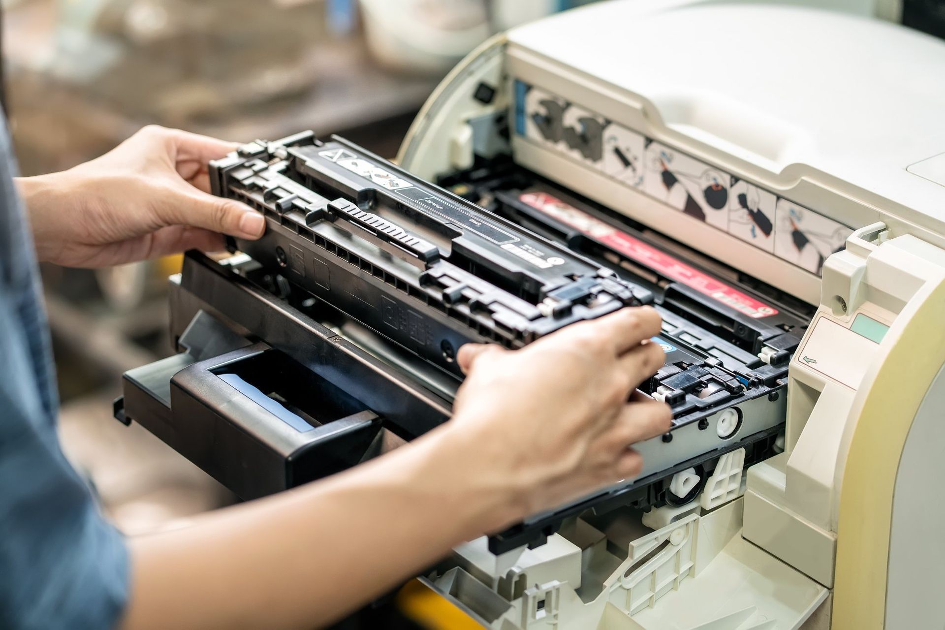 Person replacing a toner cartridge in a printer.