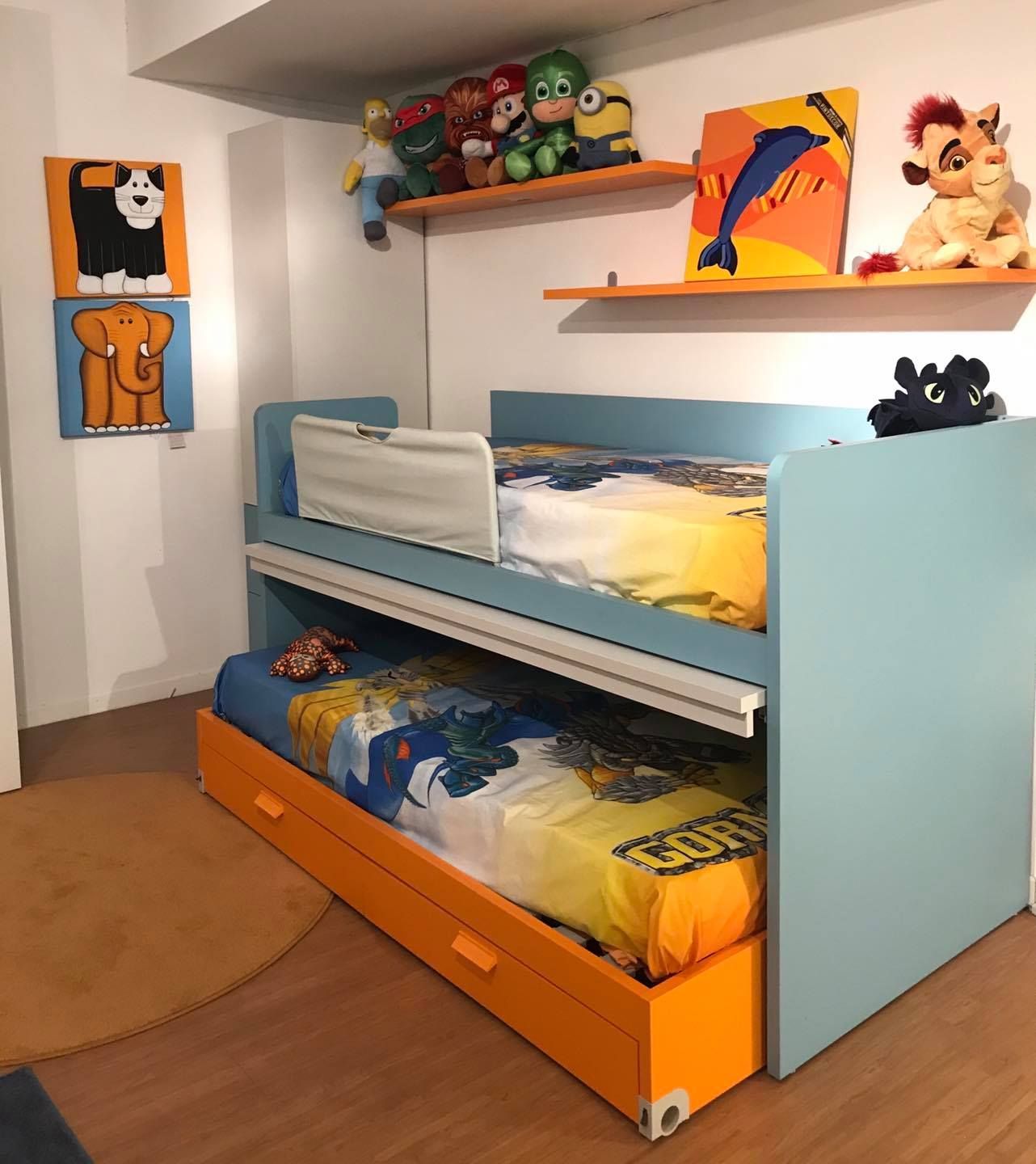 Camera da letto moderna a tema blu con scrivania, spazio contenitore incorporato e due letti; tappeto nero.