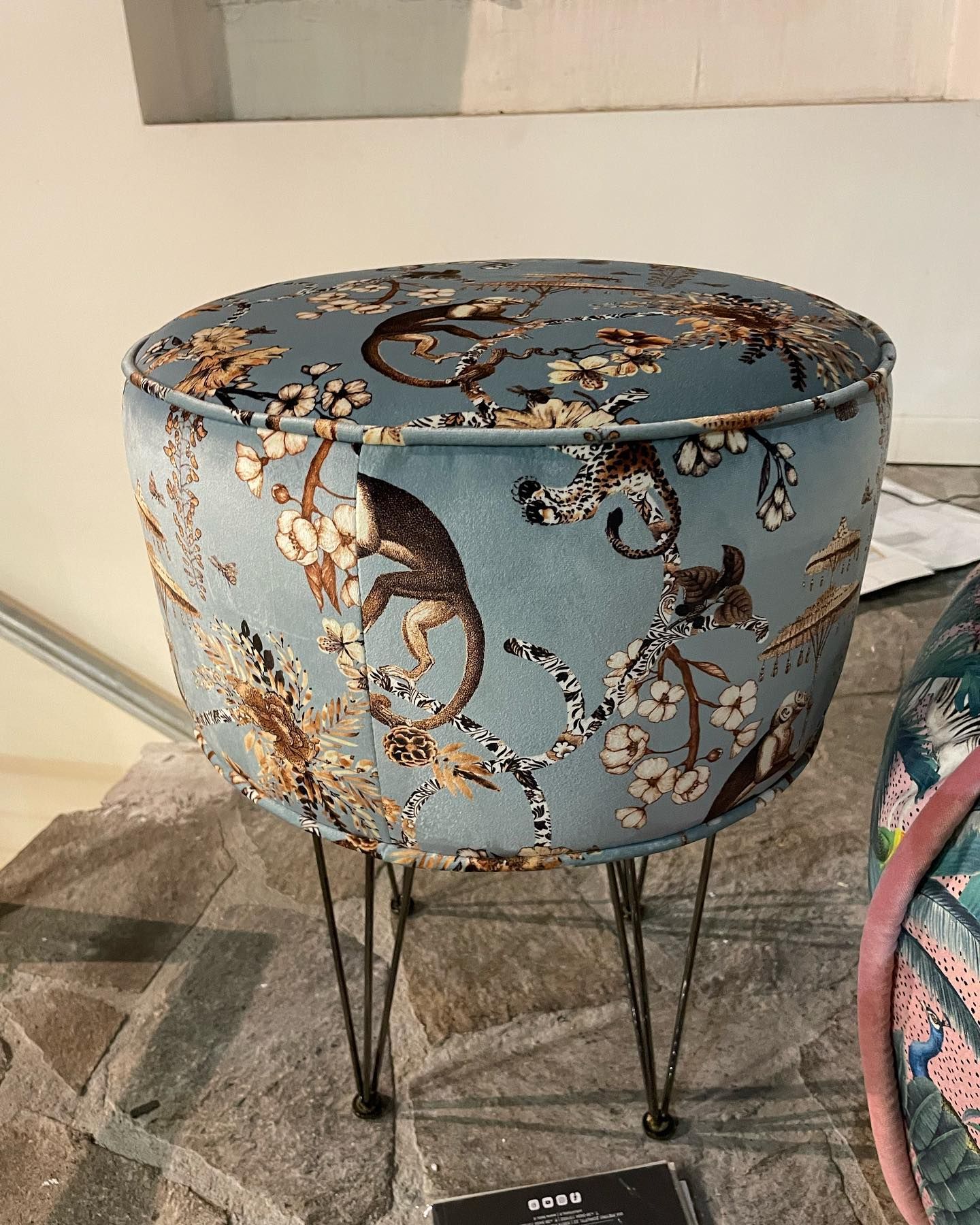 Sgabello con motivo blu e gambe a forcina.