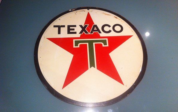 Insegna della stazione di servizio Texaco con una stella rossa e un cerchio bianco, finiture nere e una T verde.