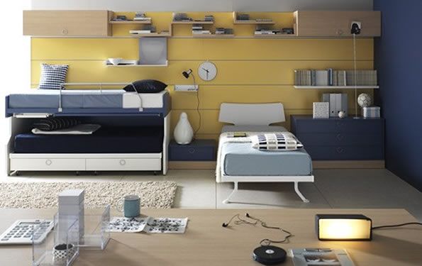 Camera da letto moderna con dettagli blu e gialli, due letti, scaffali e una scrivania.