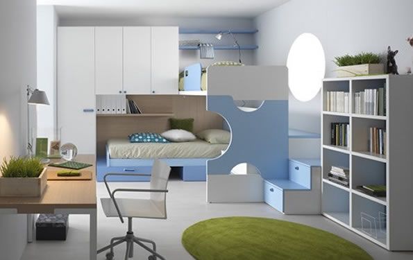 Moderna camera da letto blu e bianca con scrivania, letto a castello e libreria, impreziosita da un tappeto verde.