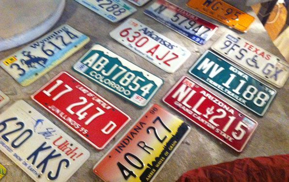 Raccolta di targhe colorate, che mostrano vari stati e numeri, sparse su una superficie.
