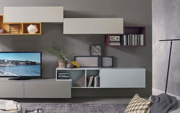Soggiorno moderno con pareti grigie, mensole sospese, TV e oggetti decorativi.