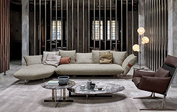 Soggiorno con mobili moderni: divano componibile, tavolino in marmo, poltrona, lampada da terra.