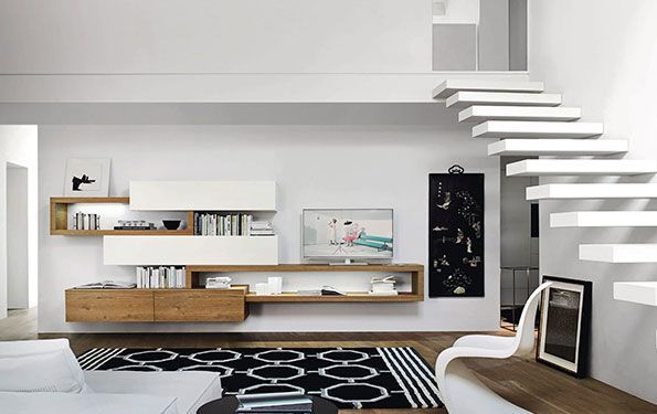 Soggiorno moderno con pareti bianche, mensole sospese, dettagli in legno e una scala.