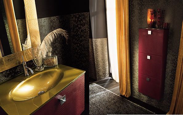 Bagno color oro e bordeaux con lavandino, specchio e mobiletto vicino alla finestra con tende gialle.