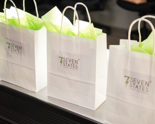 Three 7 seven states bags are lined up on a table