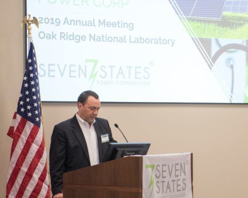 A man stands at a podium giving a presentation at the seven states national laboratory