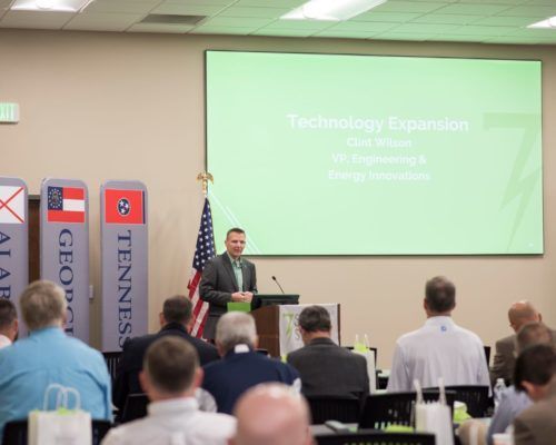 A man is giving a presentation to a group of people in a conference room.