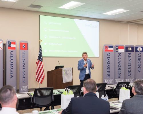 A man is giving a presentation to a group of people in a classroom.