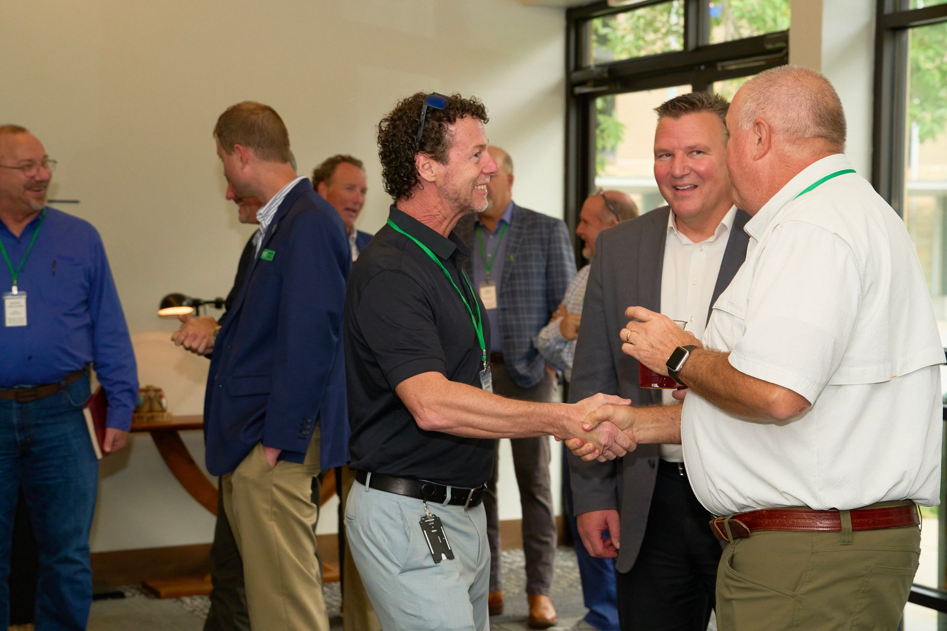 A group of men are shaking hands in a room.