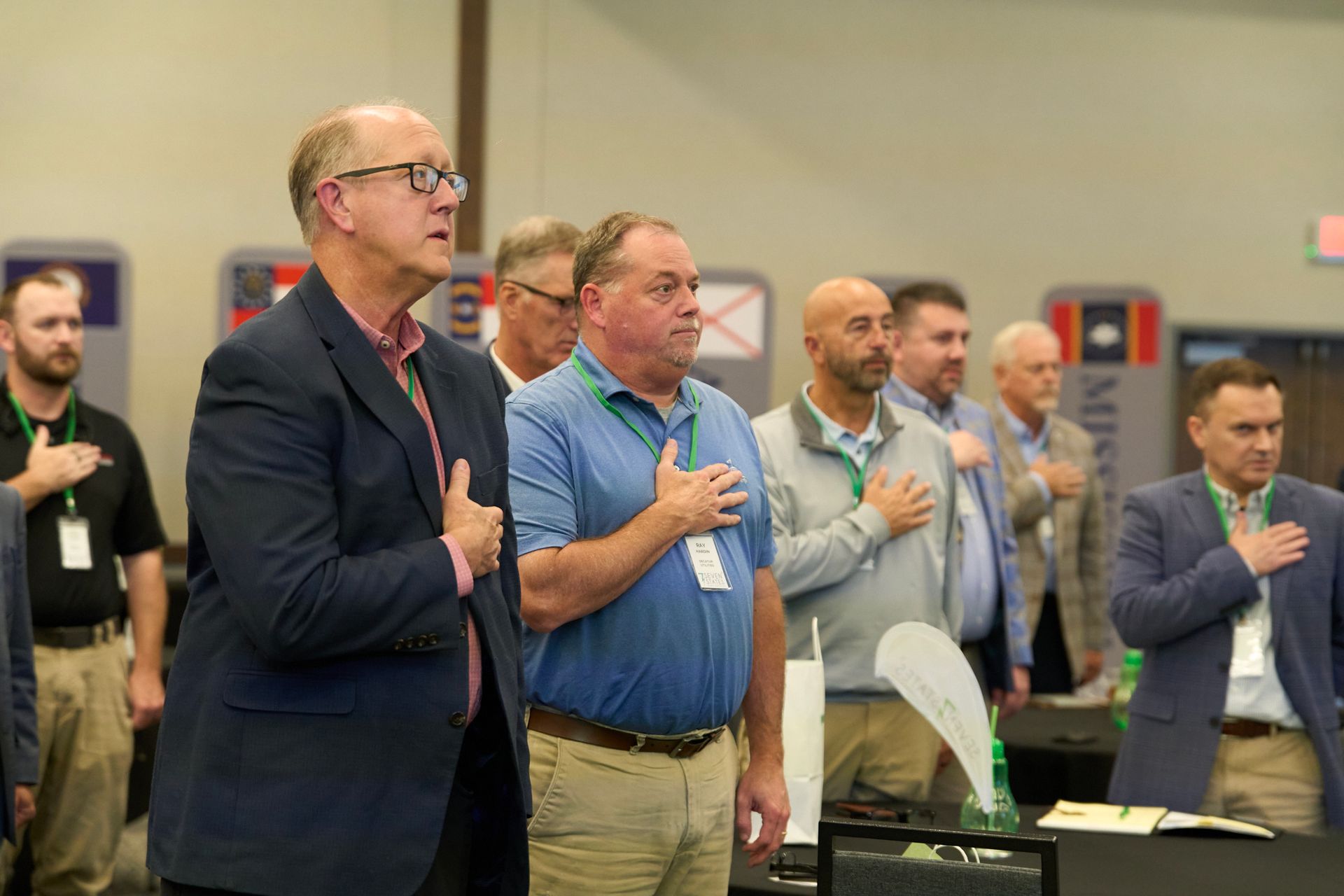 A group of men are standing in a line with their hands on their chests.
