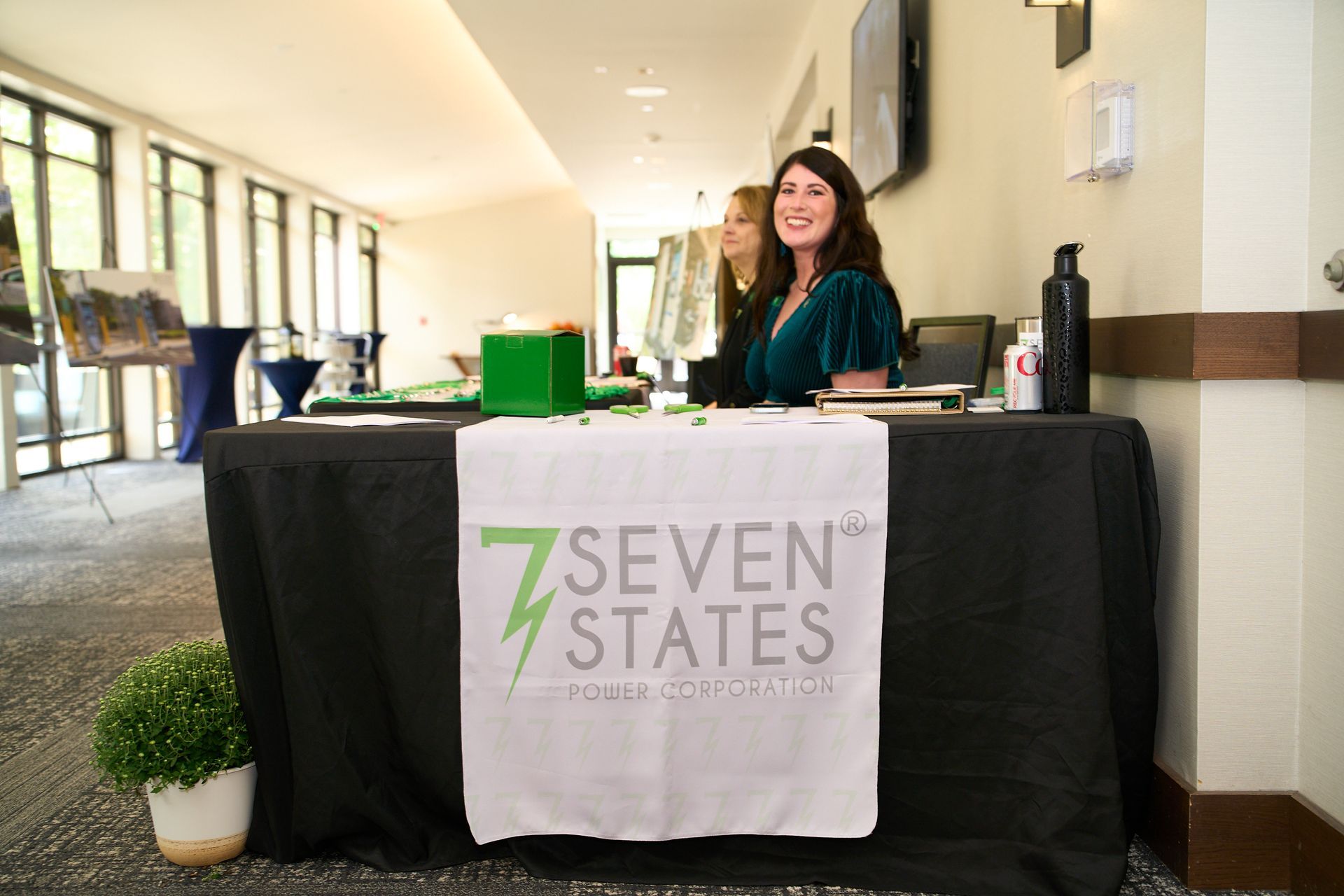 A woman is sitting at a table with a sign that says seven states.