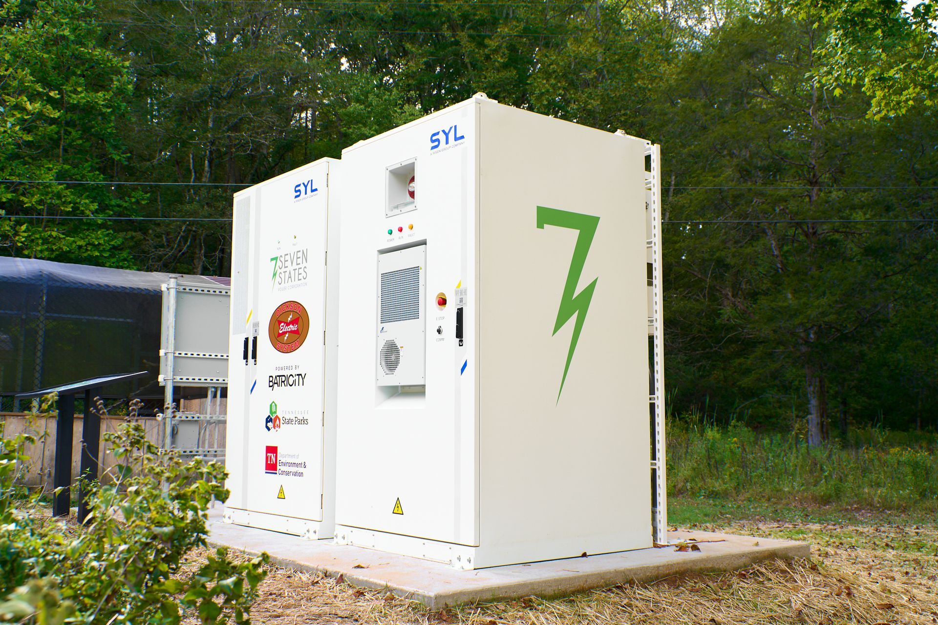 A white box with a green lightning bolt on it is sitting in the middle of a field.