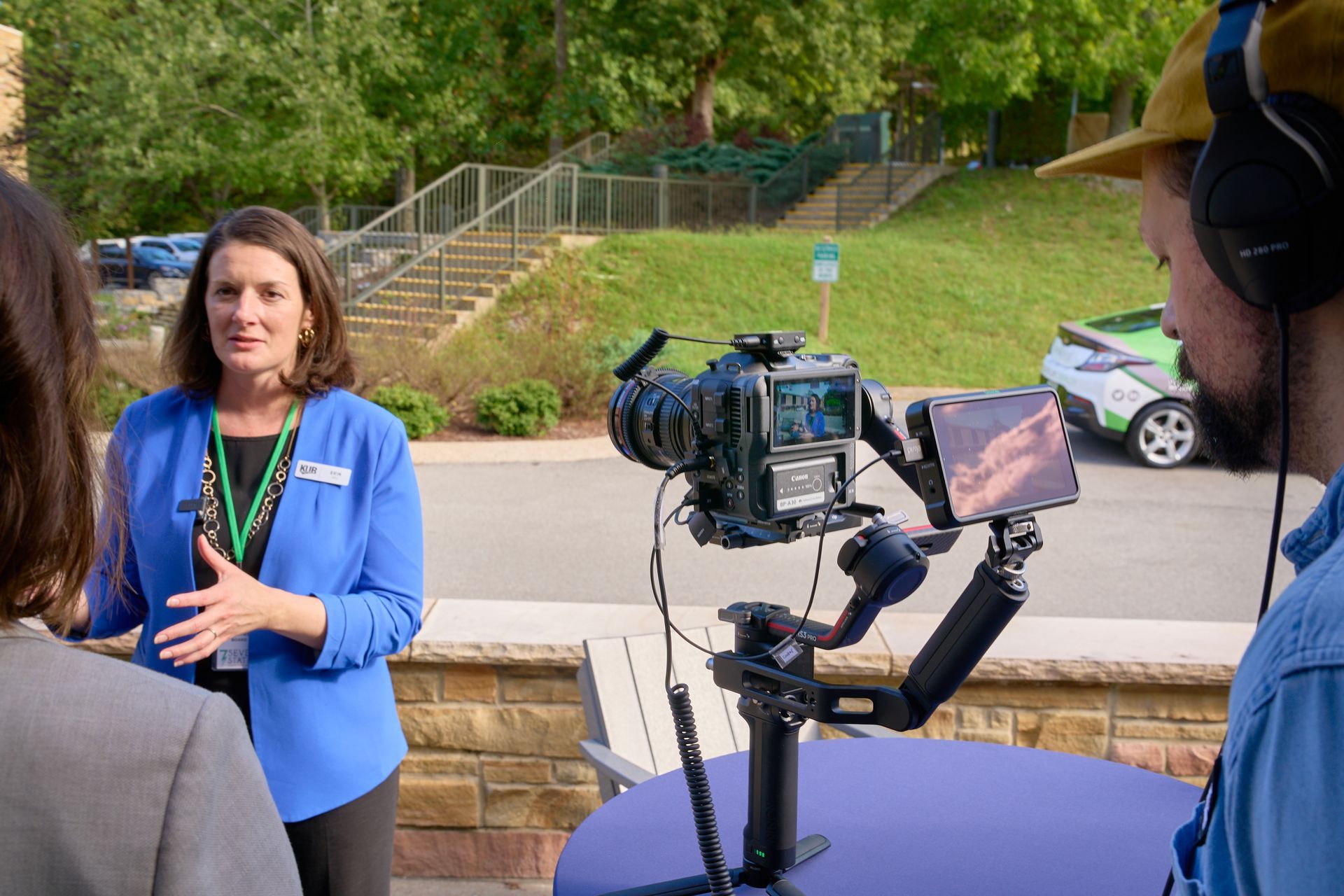 A woman is talking to a man in front of a camera.